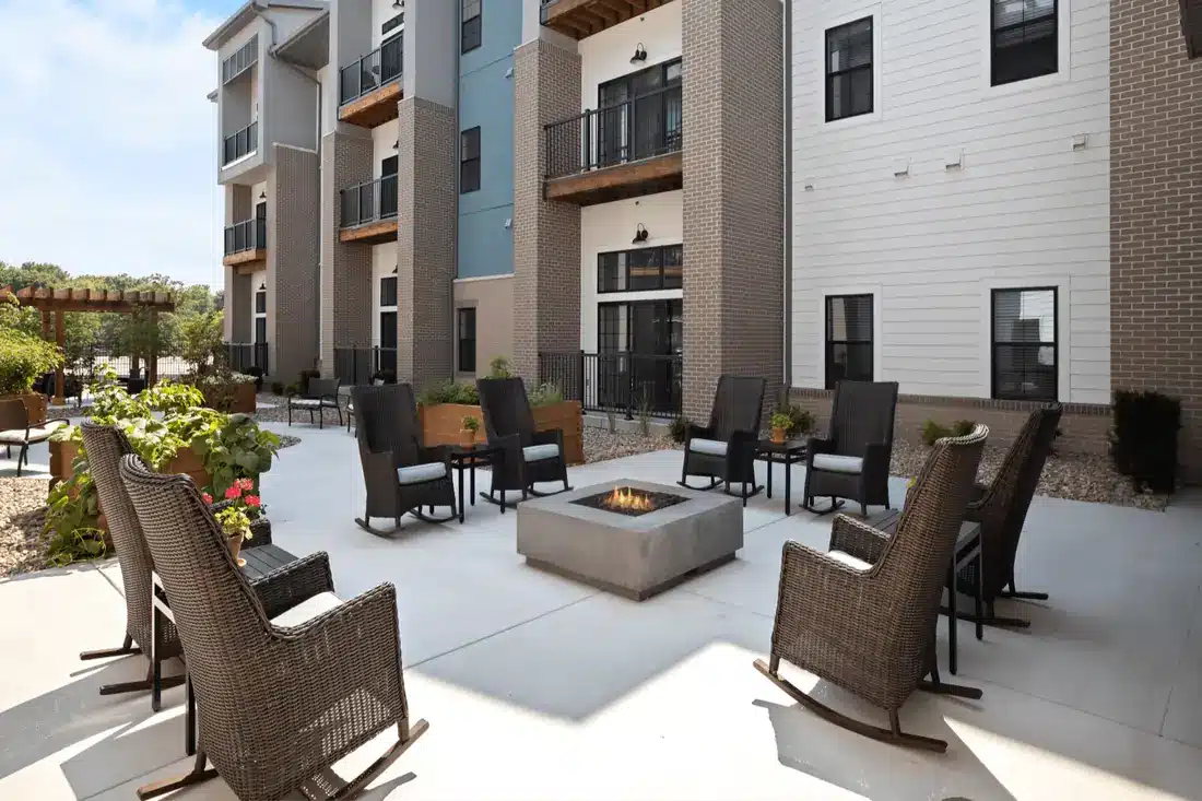 Outdoor courtyard with fire pit and rocking chairs at Novel Place